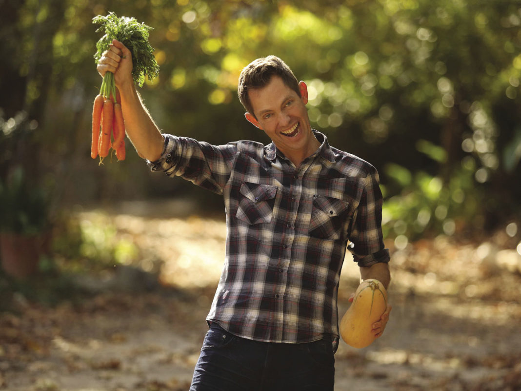 Ocean Robbins holding vegetables.