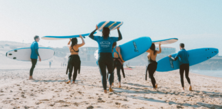 Active people practice surfing on the beach