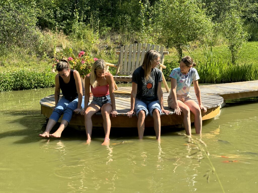 Ladies sit with their feet in the Koi Pond